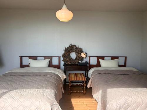 a room with two beds and a table with a mirror at 真鶴町ペットと泊まれてBBQも可能な広々ワンフロア貸切apartment Hotel途乃中 in Manazuru