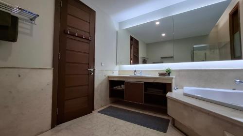 a bathroom with a sink and a large mirror at Casa Como Ciumbuleuit - spacious 3 Beds Townhouse in Bandung