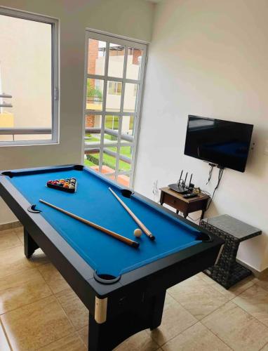 a pool table in a living room with cuesticks at Casa Sauces Sur, alberca, billar, roof garden privado in Emiliano Zapata