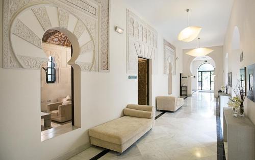 a living room with a couch and a chair at Hospes Palacio del Bailio, a Member of Design Hotels in Córdoba
