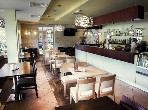 un ristorante con tavoli e sedie e un bar di Eden a Rydzyna