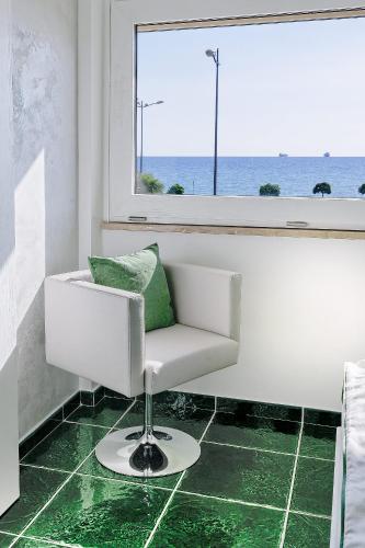 a white chair sitting in a room with a window at La Madegra Seasuite in Salerno
