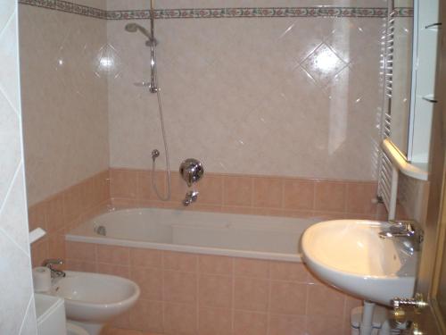 a bathroom with a tub and a sink and a toilet at San Cristoforo in Canazei