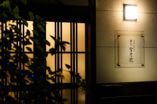 a window with a light on the side of a building at 一棟貸切 森のお風呂とアウトドアサウナ 日光雪月花 in Nikko