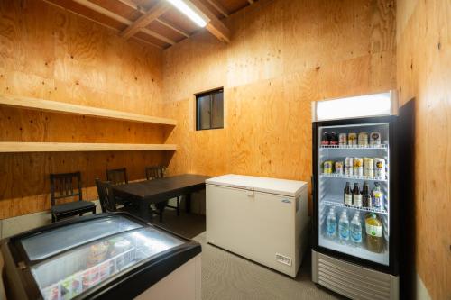 a room with a soda machine and a table at 一棟貸切 森のお風呂とアウトドアサウナ 日光雪月花 in Nikko