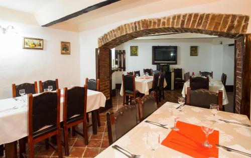 a dining room with tables and chairs and a television at Cazare Turn Sebes in Sebeş