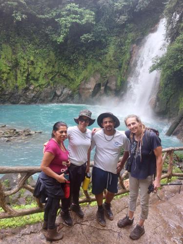 a group of people standing in front of a waterfall at Gringo Petes Too in Fortuna