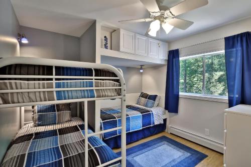 キリングトンにあるHeavenly K new luxury two family house with hot tubの二段ベッド2組、シーリングファンが備わる客室です。