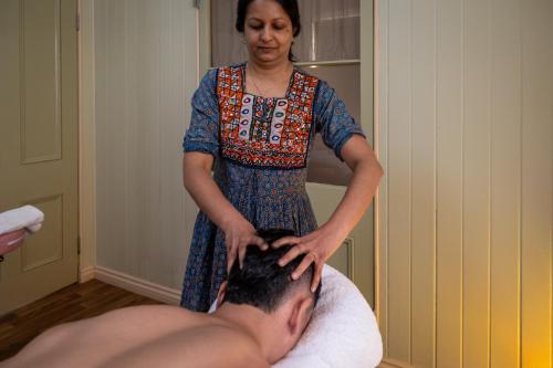 a woman is giving a man a massage at Krishna Farm Retreat in Coolabine