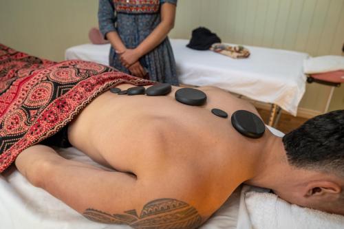 a man with sunglasses on his back on a bed at Krishna Farm Retreat in Coolabine
