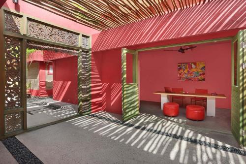a pink house with a table and red walls at PinkCoco Gili Trawangan - Constant Surprises - for Cool Adults Only in Gili Trawangan