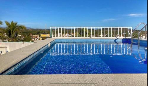 a large swimming pool with blue water in it at Apartment 4 Maleconcito del Sol Barra de Navidad in Barra de Navidad