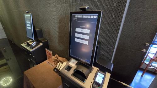 a computer screen on top of a cash register at Hotel R14 in Kaohsiung