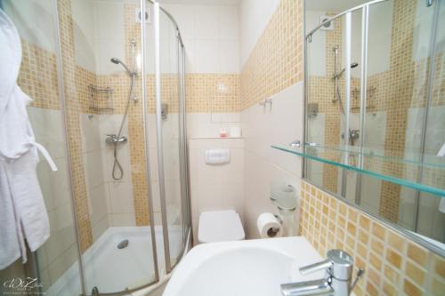 La salle de bains est pourvue d'une douche, de toilettes et d'un lavabo. dans l'établissement Apartamenty Nautilus, à Świnoujście