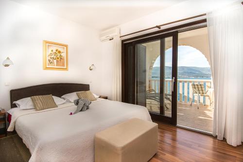 a bedroom with a large bed and a balcony at Hotel Vila Tina in Trogir