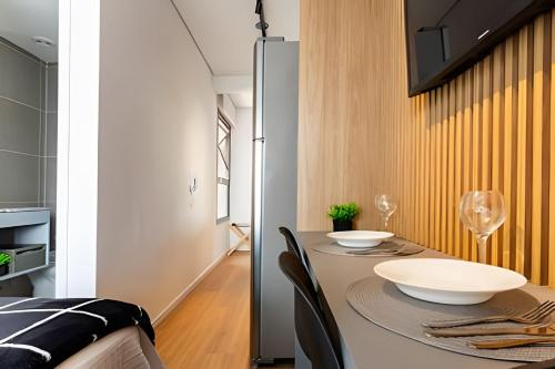 a dining room with a table with two bowls on it at Nik Perdizes in Sao Paulo