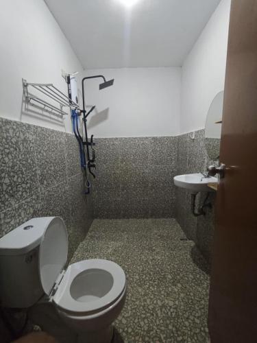 a bathroom with a toilet and a sink at Buhay Probinsya - Bubolongan in El Nido