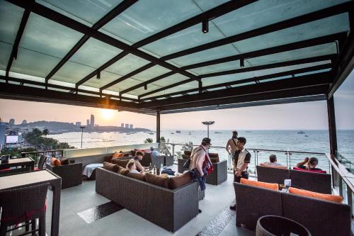 een balkon met uitzicht op het strand van een restaurant bij Serenotel Pattaya in Pattaya