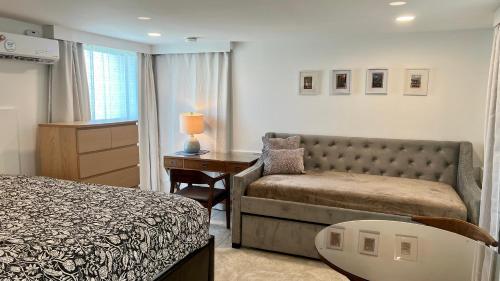 a bedroom with a bed and a couch and a desk at 3 doors down to New Orleans , Excellent location! in Arabi