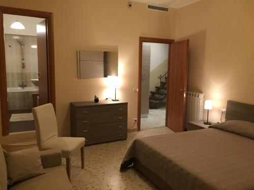 a bedroom with a bed and a chair and a mirror at La terrazza sul borgo in Serracapriola