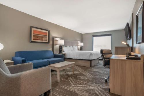 una camera d'albergo con un letto e un divano blu di Best Western Plus Jackson Downtown Coliseum a Jackson