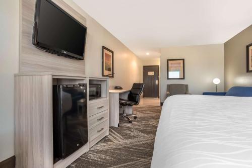 a hotel room with a bed and a flat screen tv at Best Western Plus Jackson Downtown Coliseum in Jackson