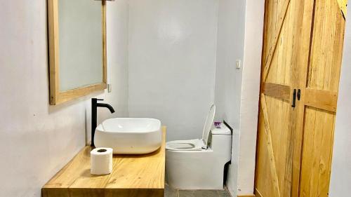 a bathroom with a white toilet and a wooden counter at AA Jungle Guesthouse in San Juan