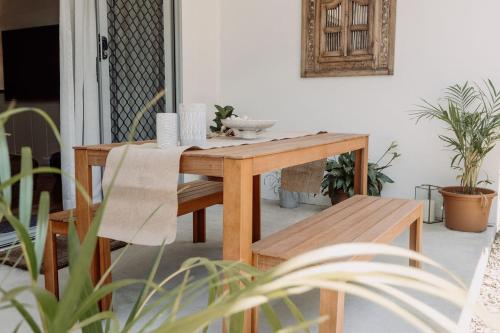 a wooden table and benches in a room with plants at Resort-Style Living, Kids Park, 4 Pools, Spacious in Buderim