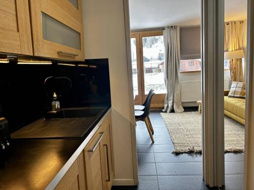une cuisine avec un évier et un salon dans l'établissement Appartement cosy 2 pièces à Plagne Centre, proche pistes et commerces - FR-1-351-231, à La Plagne Tarentaise