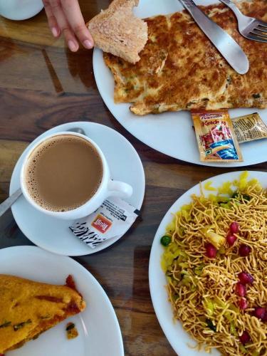 a table with plates of food and a cup of coffee at Kotra Haveli A Boutique Hotel by Lake Pichola in Udaipur
