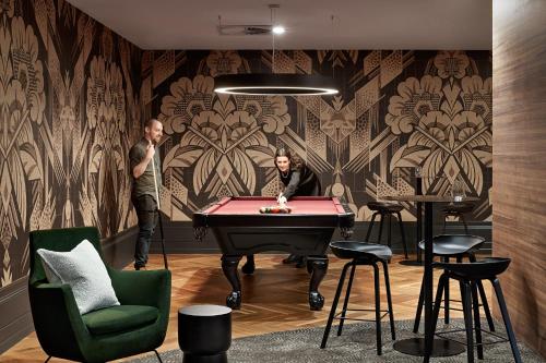 two people standing in a room with a pool table at Caulfield Apartments by Urban Rest in Melbourne