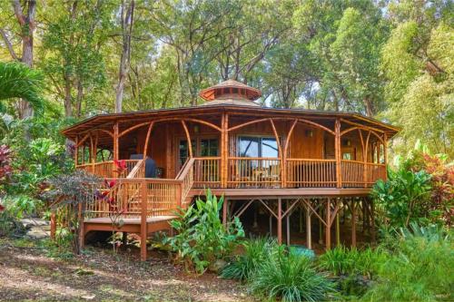 a large wooden house in the middle of a forest at Hawaiian Dream Temple in Kaupakulua