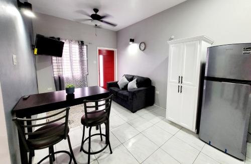 un soggiorno con tavolo e frigorifero di Rest Easy at Cunningham Suites 3 & 4 a Ottleyʼs Village