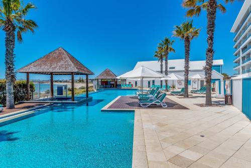 マンジュラにあるNautica Residences Mandurahのヤシの木とリゾートのスイミングプール