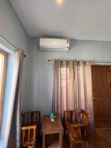 a room with two chairs and a table and a heater at Honey Bee in Leh