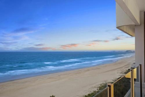a view of the beach from a balcony at Dorchester On The Beach in Gold Coast