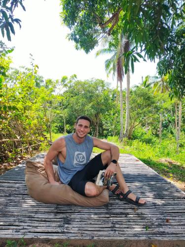 a man sitting on a wooden boardwalk with a woman at Nature's Cabin in Donsol