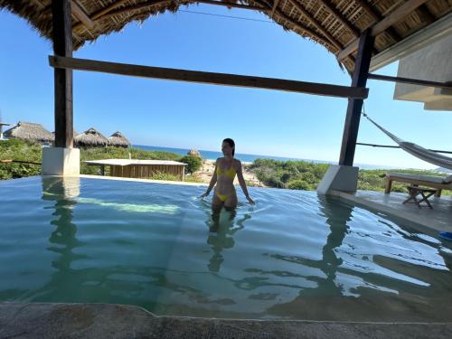 a woman standing in the water in a swimming pool at Casa Gitana in Chamuscadero