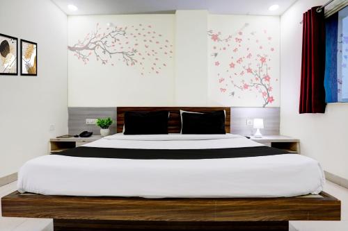 a bedroom with a large bed with white sheets at Super Townhouse Hoshangabad Road Near Aashima Mall in Bhopal