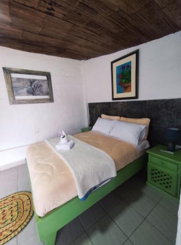 a bedroom with a large bed with a green and white bed sidx sidx sidx at Finca San Alejandro in Cotacachi