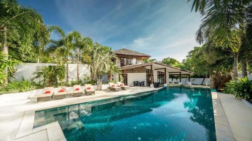 a swimming pool with chairs and a house at Beach Republic Koh Samui in Lamai