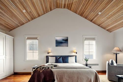 a bedroom with a large bed with a wooden ceiling at Piermont Retreat in Swansea