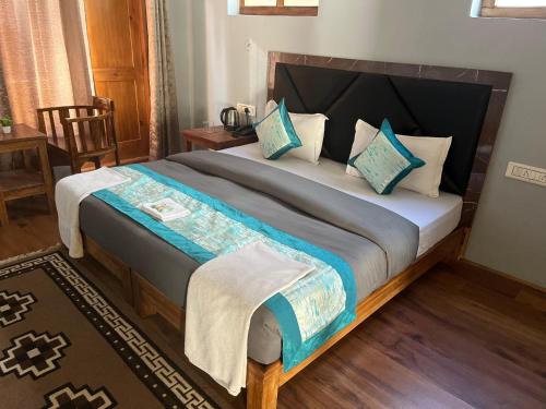 a bedroom with a large bed with blue pillows at Honey Bee in Leh
