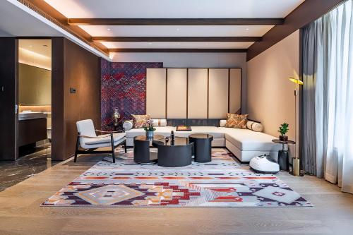 a living room with a couch and a table at Hotel Indigo Jiuzhai by IHG in Jiuzhaigou