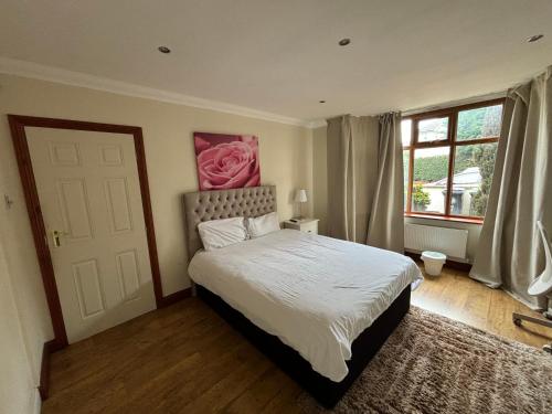 a bedroom with a bed with a pink rose on the wall at Shared house on Southmead in Bristol