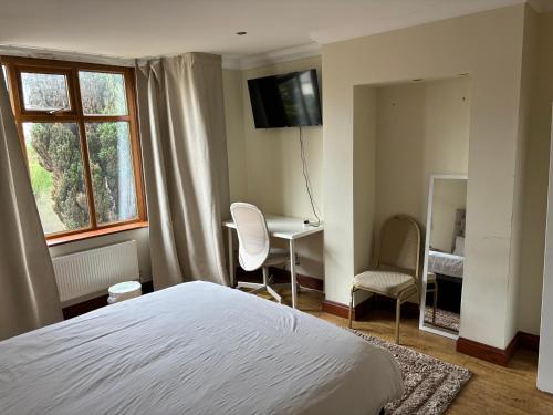 a bedroom with a bed and a desk and a window at Shared house on Southmead in Bristol
