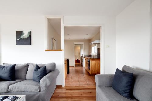a living room with two couches and a kitchen at Piermont Retreat in Swansea