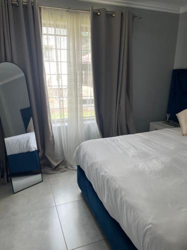 a bedroom with a bed and a large window at Masana at Homely Escape in Phalaborwa