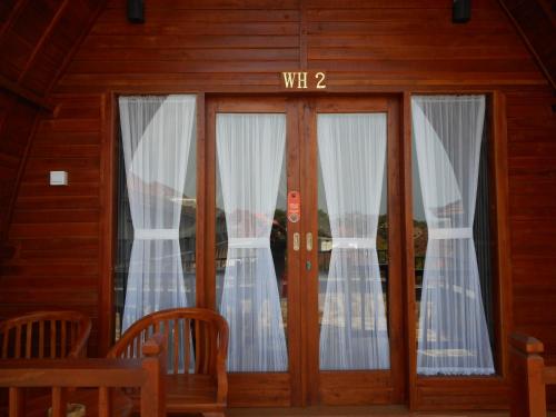 a wooden door with a sign that reads wii at Grand Sinar Indah in Legian