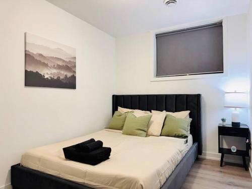 ein Bett mit einem schwarzen Kopfteil in einem Schlafzimmer in der Unterkunft Luxury Stay Near Niagara Falls in Niagara Falls